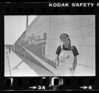 Muralist Jane Golden standing before unfinished mural in Santa Monica, Calif., 1981