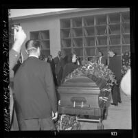 Actress Elsa Lanchester laying flowers on casket of her husband Charles Laughton in Los Angeles, Calif., 1962