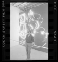 Neon Artist Lili Lakich standing with her work "Love in Vain" in Los Angeles, Calif., 1984