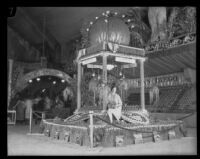 Woman sits on the Sacramento and Oroville display at the National Orange Show, San Bernardino, 1926