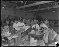 Vendors wrap up flowers for customers at the flower market, Los Angeles, 1935