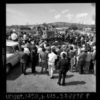 Crowd surrounding bulldozer, driven by Governor Ronald Regan, at groundbreaking for Harbor Freeway expansion, Los Angeles, 1968