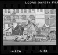 Homeless woman with two filled shopping carts in Los Angeles, Calif., 1981