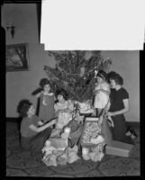 Sara Dudley, Annette Familian, Lillian Warde, Eleanor Schneider, Shirley Schneider and Dorothy Oviatt fill Christmas stockings, Los Angeles, 1934