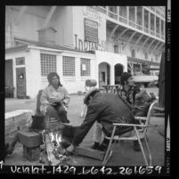 Four people sitting around campfire on Alcatraz Island during Native American Indian occupation, 1969