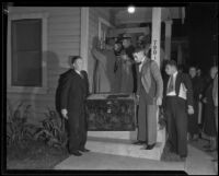 Deputy coroners T.E. Russell and Y. Ewers carry a trunk where a murder victim was found, Los Angeles, 1934