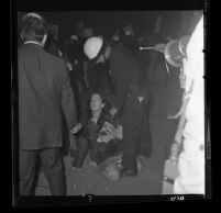 Woman sitting against police demands to disperse at demonstration at Century Plaza during President Johnson's visit, 1967