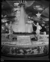 Helen Cox, 1933 queen of the LA County Fair, and Ann Harriet Pettus, 1934 queen of the LA County Fair, posing next to the Los Angeles exhibit, Pomona, 1934