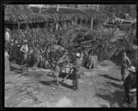 Man with deer next to a rustic animal pen at the Old Spanish Days Fiesta, Santa Barbara, 1932