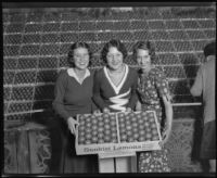 Three women hold a box of lemons at the National Orange Show, San Bernardino, 1931