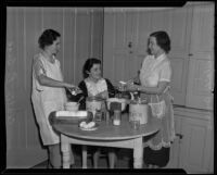 Cecilia La Sage, Anita Arnold, and Adelaide Wagner, members of the Catholic Women's Club Juniors bake for Christmas party, 1935