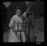 Carla Mitchell, a student at University Elementary School, spins yarn on spinning wheel of Pilgrim era, 1958