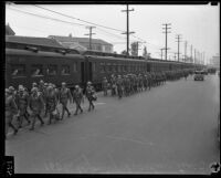 California National Guard members walking alongside train on Exposition Boulevard, Los Angeles, circa 1928-1939