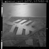 Aerial view of coastline and Marina del Rey, barren expect for a few docks, Calif., 1963