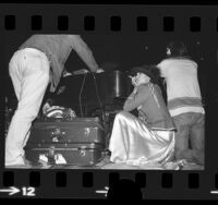 Bianca Jagger crouched behind piano at Rolling Stones concert to benefit Nicaragua in Los Angeles, Calif., 1973