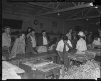 Flower market vendors wrap up flowers for waiting customers, Los Angeles, 1935