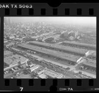 Aerial view of Los Angeles Wholesale Produce Market on Central Avenue and downtown skyline, 1986