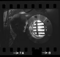 Physicist Kenneth R. Mackenzie looking into plasma chamber at UCLA, Calif., 1974