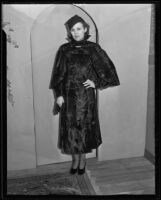 Woman models fur (?) dress, cape, and hat at the Times' fashion show, Los Angeles, 1935