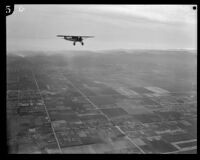 Aerial view of fields, streets, mountains, and airplane, Los Angeles, [1930s?]