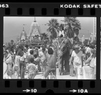 Painted elephants with riders and floats parading down boardwalk during Venice Beach Festival of the Chariots in Venice, Calif., 1980