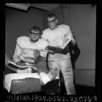 Two California Institute of Technology football players in uniforms studying physics, 1965