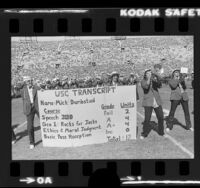 Stanford University's band pre-game performance with sign reading "USC Transcript..Mick Dumbstud.." in Los Angeles, Calif., 1981