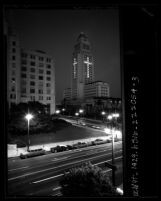 Night scene of Los Angeles City Hall with windows lit to form a cross in memorial to John F. Kennedy, Calif., 1963