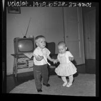 Two year old Billy Webb who was born with birth defect caused by Thalidomide, at his home dancing with younger sister in Gardena, Calif., 1964