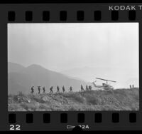 Helicopter and fire crew on ridge of mountain in Angeles National Forest, Calif., 1986