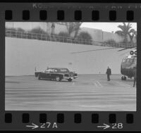 Presidential limousine awaits Lyndon Johnson and Lady Bird, who have exited a helicopter, out of frame to the right, 1967