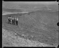 Officials or family members visit a burned out area of Griffith Park where workers died, Los Angeles, 1932