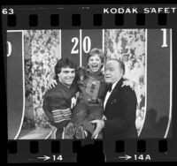 Doug Flutie and Bob Hope carrying gymnast Mary Lou Retton during taping of Bob Hope's Christmas television show, 1984