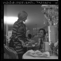 Valerie McBride serving a trout dinner to her husband, Rick in Los Angeles, Calif., 1970