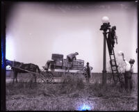 A group of men installing a lamp post, Van Nuys, 1915-1925