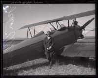 Pilot Jean Allen, standing next to a bi-plane, Los Angeles, 1923-1930