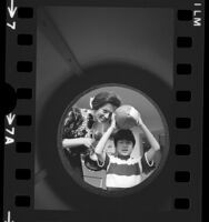 Terrance Chang and Dixie Myers placing items in an Exposition Park time capsule, Los Angeles, 1972