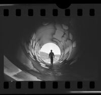 Workman walking through pipe at Castaic Hydroelectric Power Plant, Calif., 1976