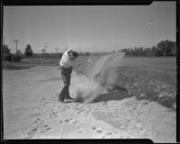 Jim Ross hitting a golf ball out of a sand trap, Los Angeles