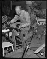 Goodwill worker paints a toy, Los Angeles, 1938