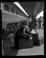 Actress Kim Novak posing for reporters on the train platform at Los Angeles Union Station, 1956