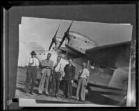 Australian aviator Sir Charles Kingsford-Smith with 4 unidentified men at an air field, 1927-1935