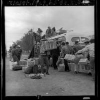 Braceros loading their belongings onto a bus for trip home to Mexico, El Centro, 1965