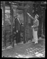 Detective Lieutenants Everett Harris and Joe Gentry inspect fire damage to a boarding house, Los Angeles, 1935