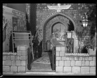 Man stands in a rug bazaar display at the Los Angeles County Fair, Pomona, 1932