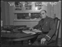 Sheriff Deputy John W. Hanby at a kitchen table with firearms, Los Angeles, 1935