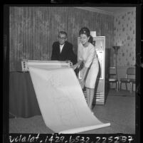 L. Pyle and Nonna Walls examine a print out of "Miss Formula", a computer created rendering of the "perfect female," Calif., 1964