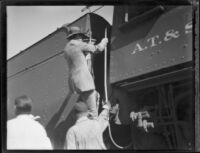 Crown Prince Gustav Adolf of Sweden clibing into in the cab, or engineer's compartment, of a train, [Los Angeles?], 1926