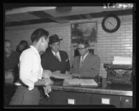 James Utley with Deputy Sheriff Stanley Uno and Attorney Harold R. Shire, from right to left, as Utley surrenders at the Hall of Justice, Los Angeles, 1946