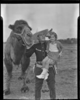 Ken Maynard introducing Colleen Fitzgerald to one of the camels in his circus, Van Nuys, 1936